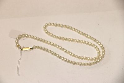 un collier de perles blanches muni d'un fermoir en or