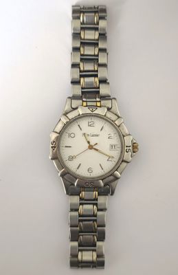 une image d'un gros plan d'une montre-bracelet sur une surface blanche