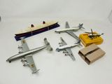 four model airplanes and a toy boat on a table