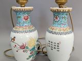 une paire de vases chinois décorés d'oiseaux et de fleurs, posés sur une table