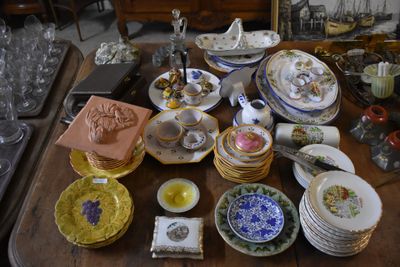 many plates and bowls on a table with a mirror in the background