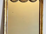 an image of a mirror with a gold frame on a white wall