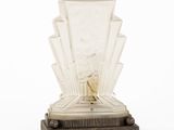 une sculpture Art déco représentant une femme en robe, posée sur un socle
