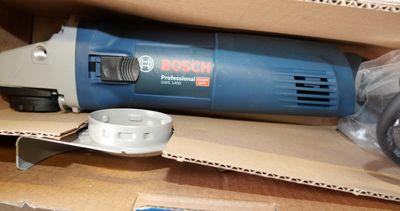 a blue and white electric sander sitting on a cardboard box