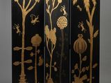 un paravent noir et doré orné d'oiseaux, de fleurs et d'arbres