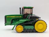 a green toy tractor with yellow wheels on a white background