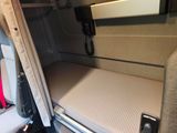 a bed in the back of a van with a phone in it