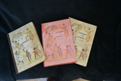 three books that are sitting on a black cloth