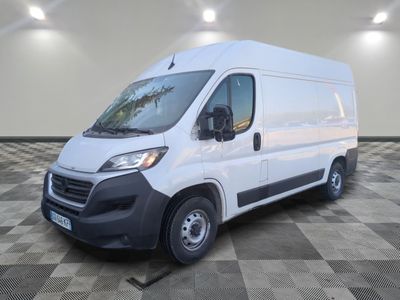 la camionnette blanche est garée sur un sol carrelé en damier