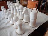 a lot of white chess pieces sitting on a table