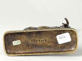 an antique bronze figurine of a bull with a tag on it ' s back