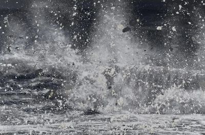 a black and white photo of a man surfing in the ocean