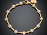 un bracelet en or orné de perles et d'une breloque en forme de cœur