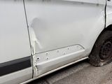 a white van that has been damaged and is parked on the side of the road