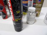 a can of chain lube next to a can of lube next to a can of lube