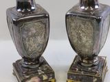 two silver vases sitting on top of each other