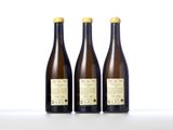 three bottles of wine sit side by side on a white surface
