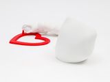 a white cup with a red handle next to a white cup