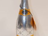 Des bouteilles de champagne sont alignées sur une surface blanche