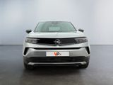 the front of a silver car in a room with a white wall