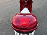 un scooter rouge et blanc garé sur le bord de la route