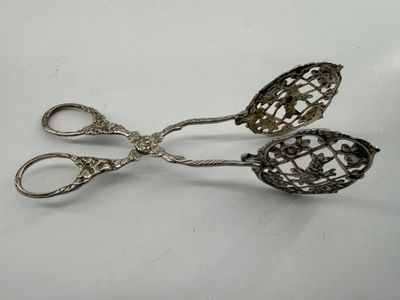 pair of antique silver plated scissors on a white surface