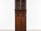 une vieille armoire en bois avec des portes vitrées et une porte sur le dessus