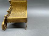a gold chair that is sitting on a gray surface