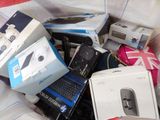 un tas d'appareils électroniques et d'autres équipements électroniques posés sur un lit