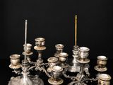 a silver plated candelab with candles on a black surface