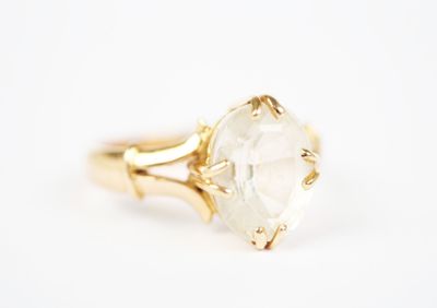 a close up of a gold ring with a clear quartz stone
