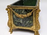 a gold and green planter sitting on a white surface