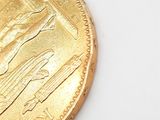 a close up of a gold coin with a picture of a woman on it