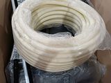 une boîte en carton contenant un gros rouleau de tuyau blanc