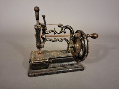 une petite machine à coudre ancienne exposée sur une table