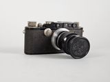 a black camera with a black lens on a white background