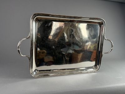 a silver tray with a handle and handles on a table