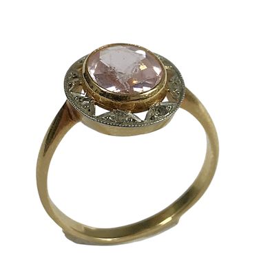 une image d'une bague en or avec une pierre rose au centre