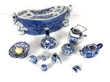 several pieces of blue and white pottery sitting on a white surface