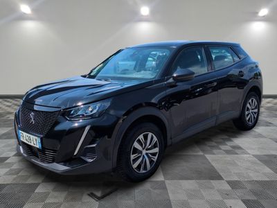 un 4x4 noir garé sur un sol en damier dans un garage