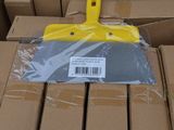 une brosse en plastique jaune posée sur une boîte en carton