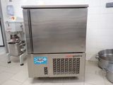 a stainless steel refrigerator in a kitchen with pots on the floor