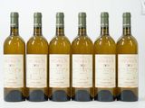 six bouteilles de vin sont alignées sur une surface blanche