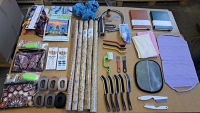 une table sur laquelle se trouvent de nombreux objets divers, notamment des ciseaux, des stylos, des ciseaux et d'autres objets