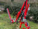 une machine rouge qui est posée dans l'herbe