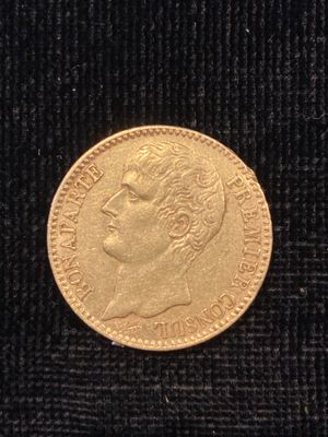 un gros plan d'une pièce d'or posée sur un tissu noir