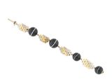a close up of a black and gold bracelet on a white background