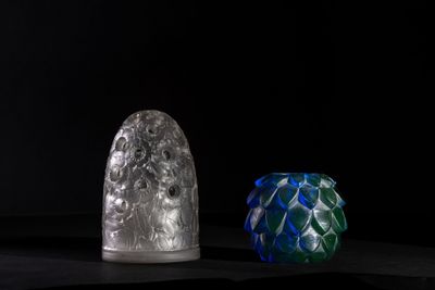 three different colored glass vases sitting on top of a black surface