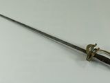 a close up of a sword on a table with a white background