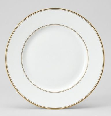 une assiette blanche et dorée, bordée d'or